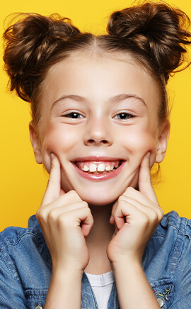 Young girl pointing to her smile