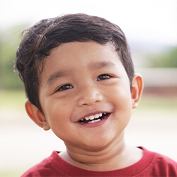 Smiling toddler boy in red shirt